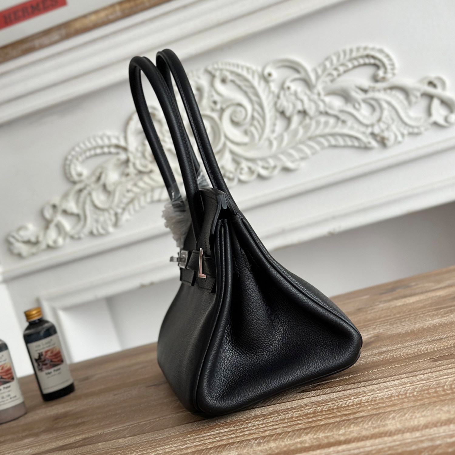 Polished Jet Black Fine Grain Slim Elongated Rectangular Hand Tote With Brushed Silvery Twist Lock Hardware And Dual Curved Top Carry Grips