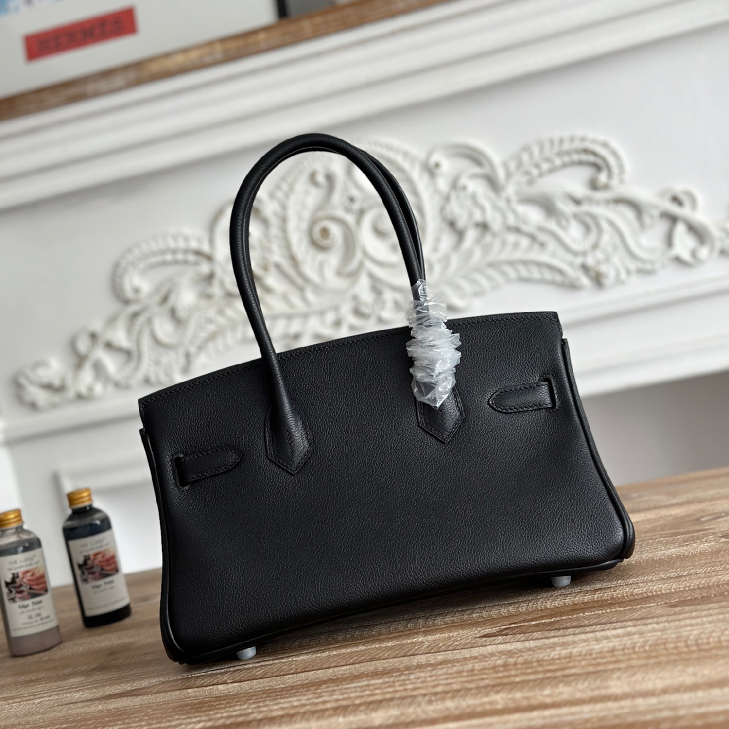 Polished Jet Black Fine Grain Slim Elongated Rectangular Hand Tote With Brushed Silvery Twist Lock Hardware And Dual Curved Top Carry Grips