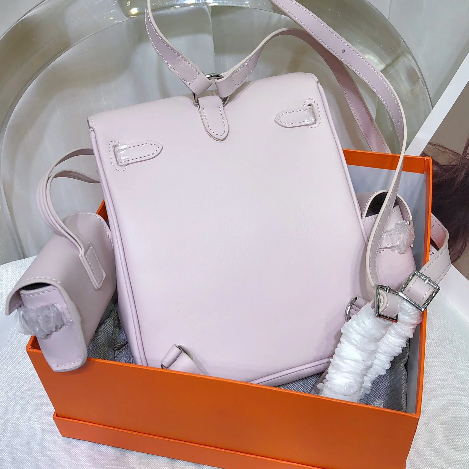 Soft Pale Mauve Fine Matte Grain Vertical Compact Backpack With Sleek Silvery Twist Flap Hardware And Slim Matching Back Rest Straps